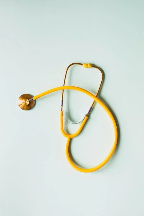 A medical stethoscope on a plain olive green background.