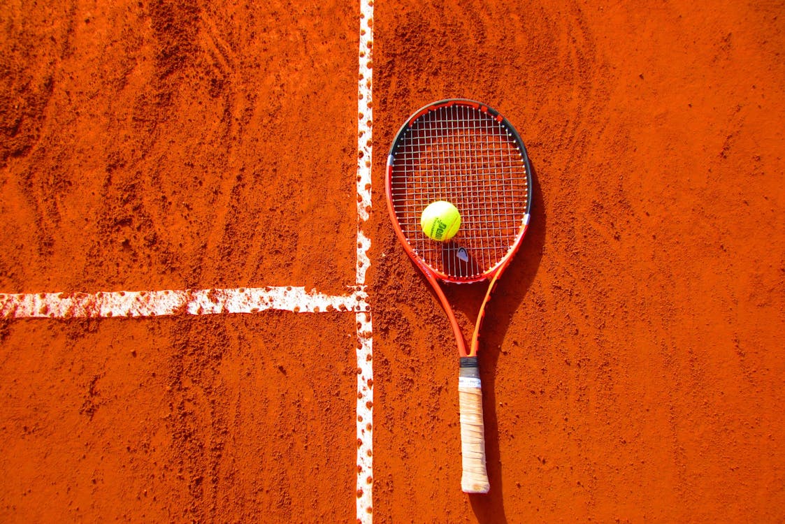 Tennis Ball and Tennis Racket on Clay Court