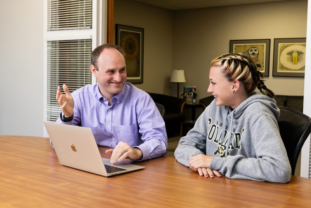 Math tutor teaching geometric concepts to a student on laptop.