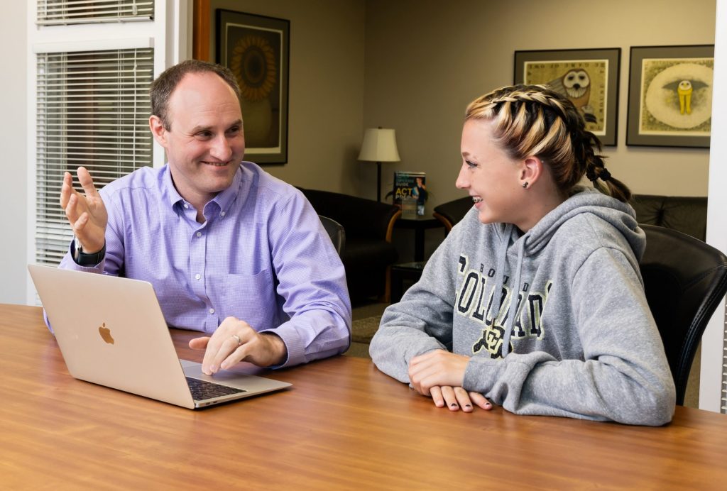 A tutor and student enthusiastically working together on chemistry homework.