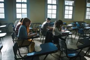 A group of students focused on taking an ACT® exam in a high school classroom setting.