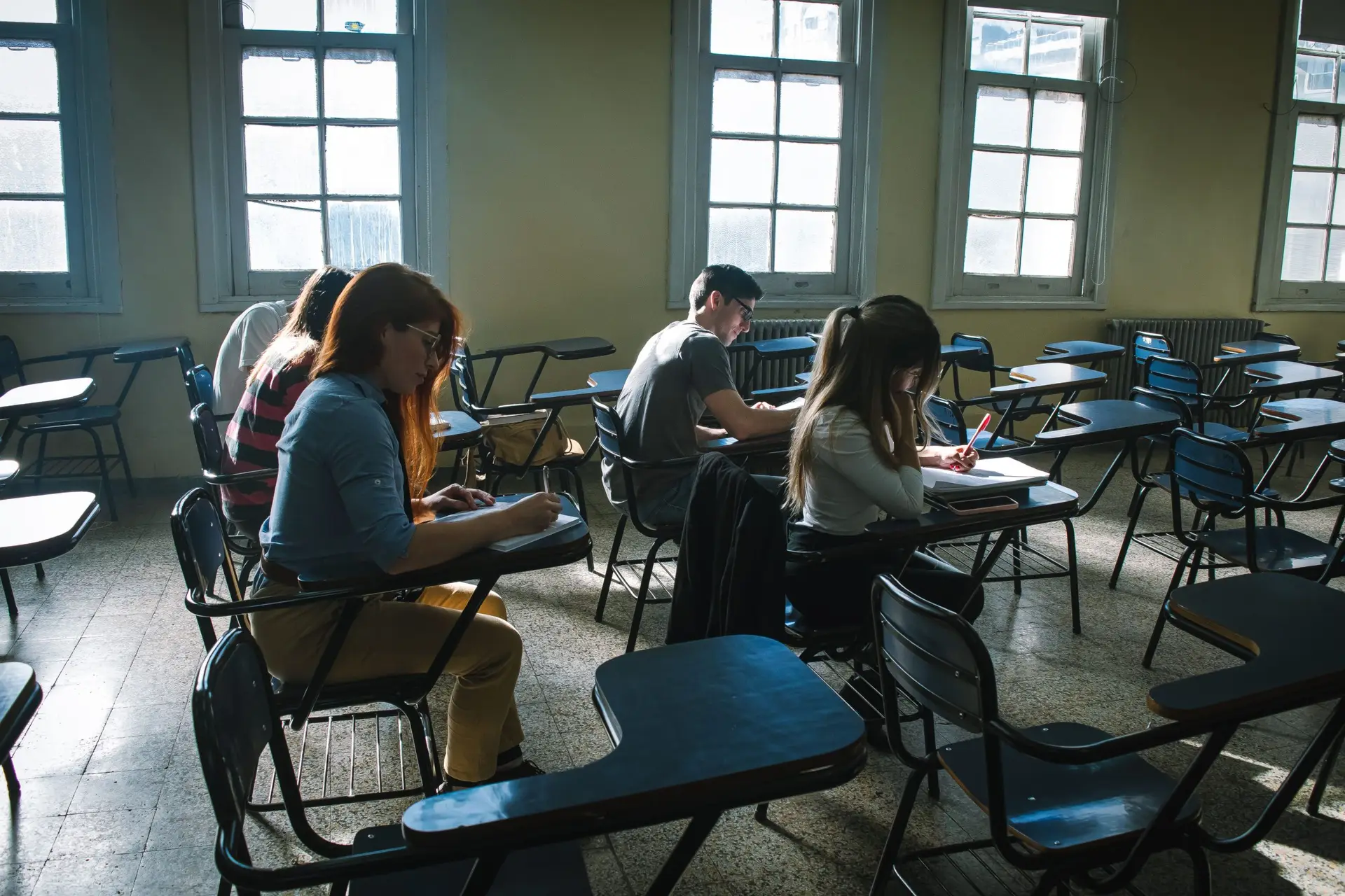 A group of students focused on taking an ACT® exam in a high school classroom setting.